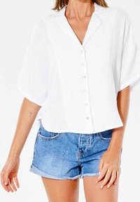 Hvid kortærmet bluse med krave og frontknaplukning. Parret med lyseblå denimshorts. Tekstureret stof.