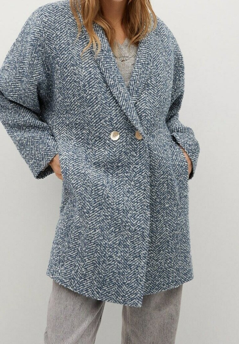 Cappotto doppiopetto in tessuto herringbone blu testurizzato con due grandi bottoni, ampi rever e tasche laterali, caratterizzato da una vestibilità comoda.