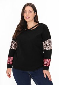 Schwarzer Sweatshirt mit V-Ausschnitt und Überkreuzdetails, Leopardenmuster-Akzente in verschiedenen Rosatönen an den Ärmeln und einer weichen Textur.