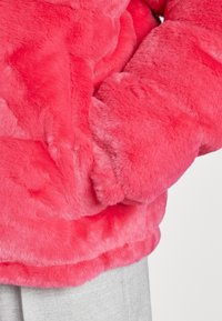 Faux fur jacket in vibrant pink. Features a soft, plush texture with a snug fit, and cuffed sleeves. No visible hardware or patterns.