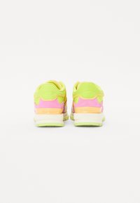 Chaussures de sport néon vertes et roses avec une tige en mesh et en suède, des accents texturés, une semelle rembourrée et une marque "GIOSEPPO" sur le talon.