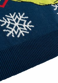 Maglione lavorato a maglia blu navy con motivi di fiocchi di neve bianchi, con polsini a costine e un vivace design grafico nella parte superiore. Texture morbida.