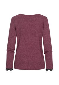 Bordeauxfarbenes Langarmshirt mit rundem Ausschnitt, aus weichem Stoff; mit schwarzen Spitzenakzenten an den Bündchen. Schlichtes Design.