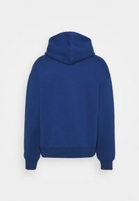 Sudadera con capucha azul de corte relajado, con una textura suave, mangas largas y puños y dobladillo de canalé. El diseño no presenta detalles en la parte frontal.