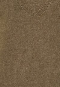 V-ringad stickad tröja i en varm brun nyans, med en strukturerad yta och mjukt tyg, designad för komfort och mångsidighet.