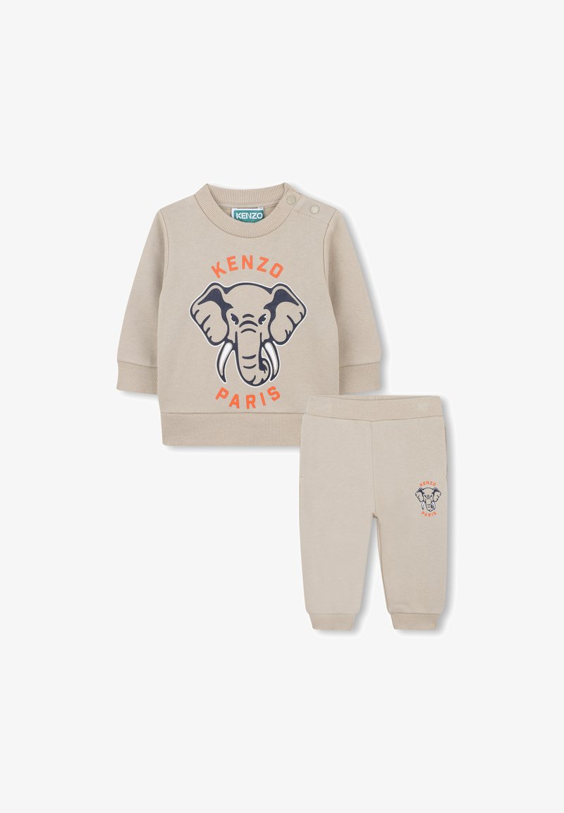 Ensemble en beige composé d'un sweat-shirt et d'un pantalon, avec un graphisme d'éléphant, le texte "KENZO PARIS", des poignets côtelés et une taille élastique sur le pantalon.