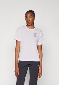 Tricou scurt cu mânecă scurtă de culoare roz deschis, cu guler rotund și un imprimeu pe buzunarul de la piept care prezintă grafice botanice. Material moale, croială relaxată.