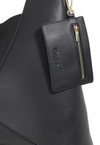 Black leather handbag featuring a smooth texture, a detachable cardholder with gold hardware, and a minimalist design.
