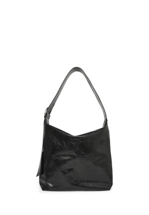 Sac à épaule en cuir noir avec une sangle unique et une texture douce, légèrement froissée, debout sur un fond blanc.