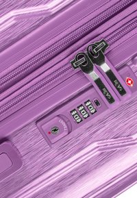 Lila Hartschalenkoffer mit gebürsteter Textur, doppeltem Reißverschluss und einem Kombinationseinschluss für Sicherheit.
