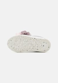 Semelle de chaussure grise avec une surface flexible et texturée. Décorée d'accents floraux doux en rose et violet près du talon. Motif blanc émaillé.