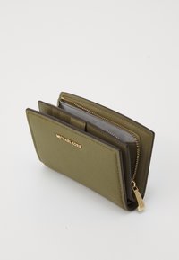 Green leather wallet with a zippered compartment, card slots, and a gold logo. Features a textured surface and rectangular shape.