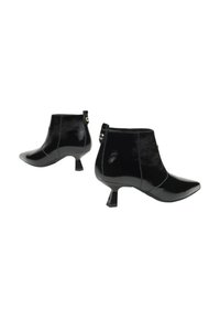 Bottines en cuir verni noir avec un bout pointu et un talon bloc, présentant un design sans coutures et un petit accent à l'arrière.