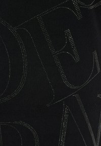Tessuto nero con una texture liscia, caratterizzato da grandi lettere decorative contornate da piccoli strass lucenti che creano un design a contrasto.