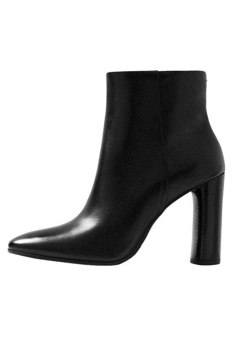 Botte chelsea en cuir noir avec un bout pointu et un talon cylindrique haut. Texture lisse avec une silhouette élégante et sans matériel visible.