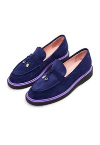 Navy suede loaferit, joissa on violetti korostus pohjan ympärillä ja hopea metalliyksityiskohta edessä. Pehmeä rakenne ja klassinen muotoilu.