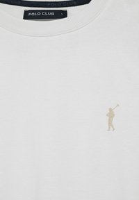 Vit bomullströja med en liten beige polo-spelare logotyp på vänster bröstområde, ribbat nacke och inga ytterligare mönster.