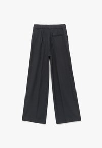 Wijdvallende broek in donkergrijs stof met verticale streepjes, met voorplooien en een achterzak voor extra detail.