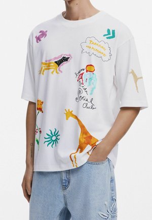 Weißes Oversize-T-Shirt mit bunten Tier- und abstrakten Drucken, darunter eine Giraffe, ein Hund, Sonne, Blume und der Schriftzug „Schätze und Freuden.“