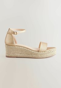 Zlatne espadrile na platformi s povišenim potplatom, koje imaju teksturirani gornji dio od umjetne kože, kaiš oko gležnja s kopčom i tkanu jutu na platformi.