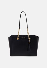 Black faux leather tote bag with gold chain accents, a tassel, and a front logo. Structured shape with dual handles for carrying.