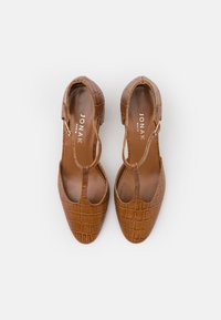 Brune sko med krokodillemønster, spids tå og åbent sidedesign, med en tynd ankelrem og en glat inderside.