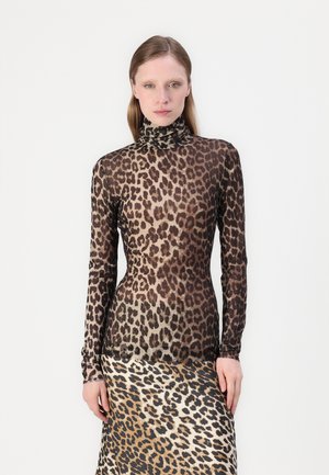 Langsleeve, passend turtleneck-top in doorzichtig materiaal met een luipaardprintpatroon, met schakeringen van bruin en zwart voor visueel contrast.