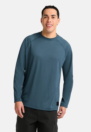 Langemouw, ronde hals shirt in tealblauw, met een gladde textuur, raglanmouwen en een subtiele zijlogo patch.
