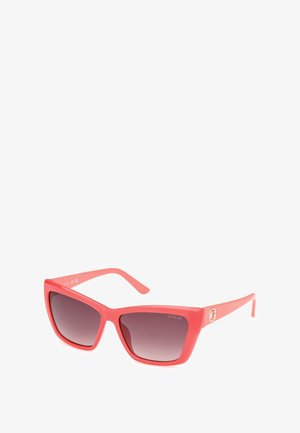 Roze plastic zonnebril met een geometrische cat-eye vorm, gradient getinte lenzen en een gouden logo accent op de poot.