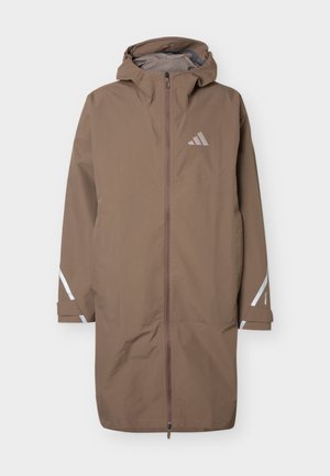 Pikk pruun veekindel mantel kapuutsiga, esilukk, rinnal helkuriga Adidas logo ning helkurdetailid varrukatel ja mansettidel.