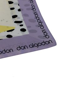 Alfombrilla rectangular púrpura con formas abstractas en blanco y amarillo, con manchas negras. Texto "don algodon" repetido a lo largo del borde.