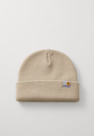 Beige strikket beanie med en foldet manchet, der har et lille firkantet mærke med et logo. Blød tekstur og fleksibel pasform.