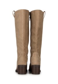 Botas de ante beige hasta la rodilla con tacón bloque, que cuentan con un cierre de cremallera y tiradores en el caña para facilitar su uso.