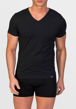 Camiseta de algodón negra de cuello en V con mangas cortas, que presenta una textura suave y un corte ajustado, junto con bóxers negros.