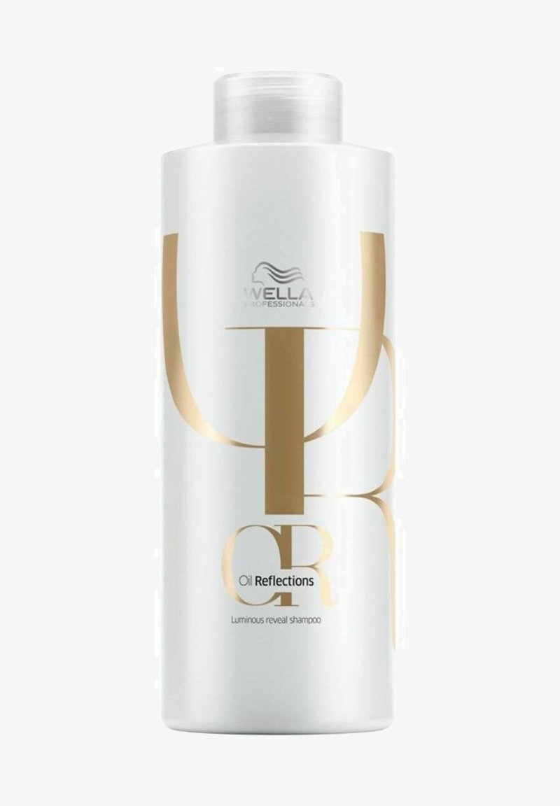 Witte shampoofles met een glanzende afwerking, grote gouden letters en een schroefdop. De tekst bevat "Oil Reflections" en "Luminous reveal shampoo."