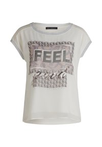 Blouse à manches courtes, couleur crème, avec un graphique rehaussé d'argent portant l'inscription "FEEL good", orné d'un motif floral et de décorations en studs.