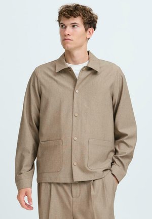 Beige button-up jacket with a collared neck, two front pockets, and a smooth texture. Light fabric with a structured, relaxed fit.