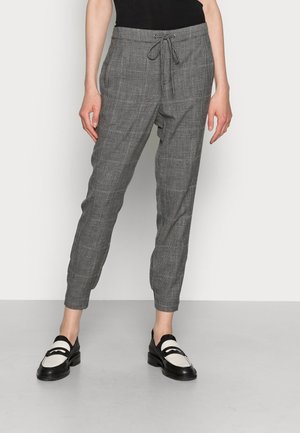 Grijze geruite tapershorts met een trekkoord in de taille, voorzien van een gladde textuur en zijzakken, gecombineerd met zwart-witte instappers.
