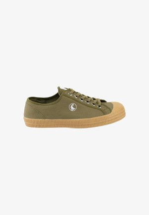 Zapatilla de lona verde oliva de corte bajo con suela y puntera de goma marrón, ojales metálicos, cordones y un pequeño logo circular en el lateral.