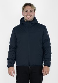 Veste isolée bleu marine avec fermeture éclair à l'avant, capuche, poignets élastiques et un écusson avec logo sur la manche. Texture de tissu lisse et léger.