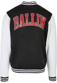 Black and white varsity jacket featuring red "BALLIN" text on the back, striped ribbed collar, cuffs, and waistband. Smooth fabric texture.