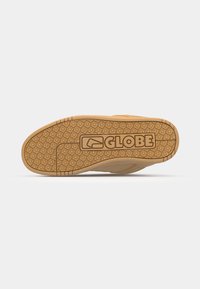 Tan sneaker sole with rubber traction pattern, featuring a rectangular "GLOBE" logo in the center and textured lines along the edges.