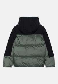 Puffjacka med huva, färgblandad design i mörkgrön och svart, med quiltad textur och elastiska muddar.