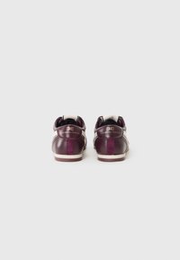 Burgundy leather sneakers with cream accents; features a smooth texture, logo detail on the heel, and a contrasting velvet stripe.