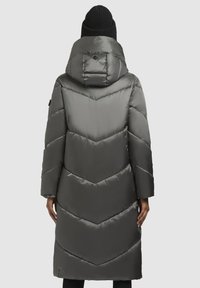 Lange pufferjas in donkergrijs met een chevronpatroon, voorzien van een capuchon en textielstof. Glad, geïsoleerd exterieur met een strakke afwerking.