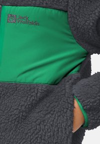 Fleecejack met een grijze textuur aan de buitenkant en een groene gladde paneel. Beschikt over een logo en een binnenzak met een gestikt rand.