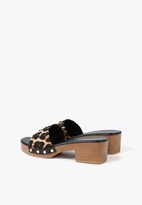 Sandalias de plataforma con estampado de leopardo, correas de tela negra, tacones de bloque de madera y acentos de tachuelas doradas. Plantillas interiores de piel suavemente negra y bordes redondeados.