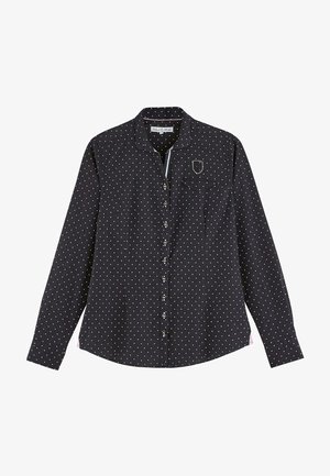 Chemise noire à boutons avec des pois blancs, à manches longues, un col et une poche poitrine. Le tissu semble lisse avec un léger éclat.