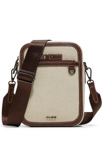 Krémová plátěná crossbody taška s hnědými syntetickými koženými akcenty, nastavitelným hnědým popruhem, přední kapsou na zip a vyraženým logem značky na spodní straně.