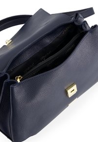 Marineblaue Lederhandtasche mit strukturiertem Finish. Verfügt über einen goldenen Verschluss und eine innere Reißverschlusstasche. Öffnet sich zu einem gefütterten Fach.